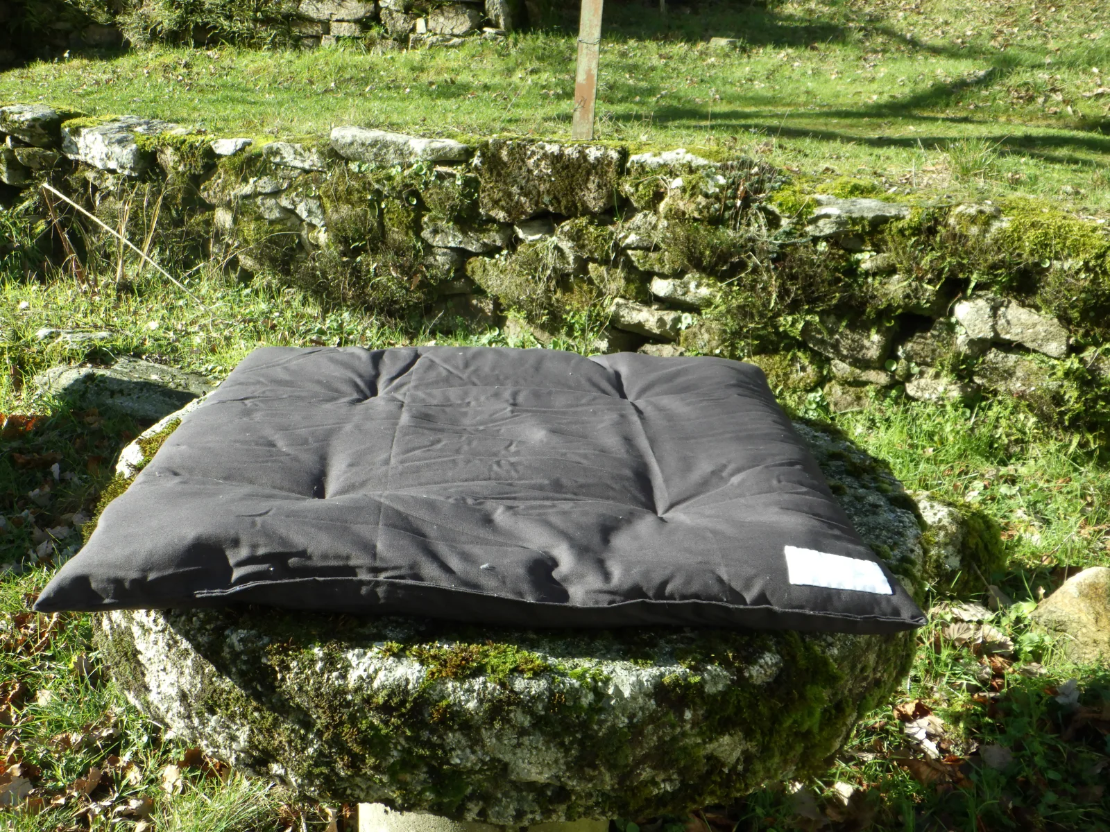 Zabuton artisanal noir traditionnel posé à plat pour amortir les genoux et malléoles en zazen — Atelier Myokan